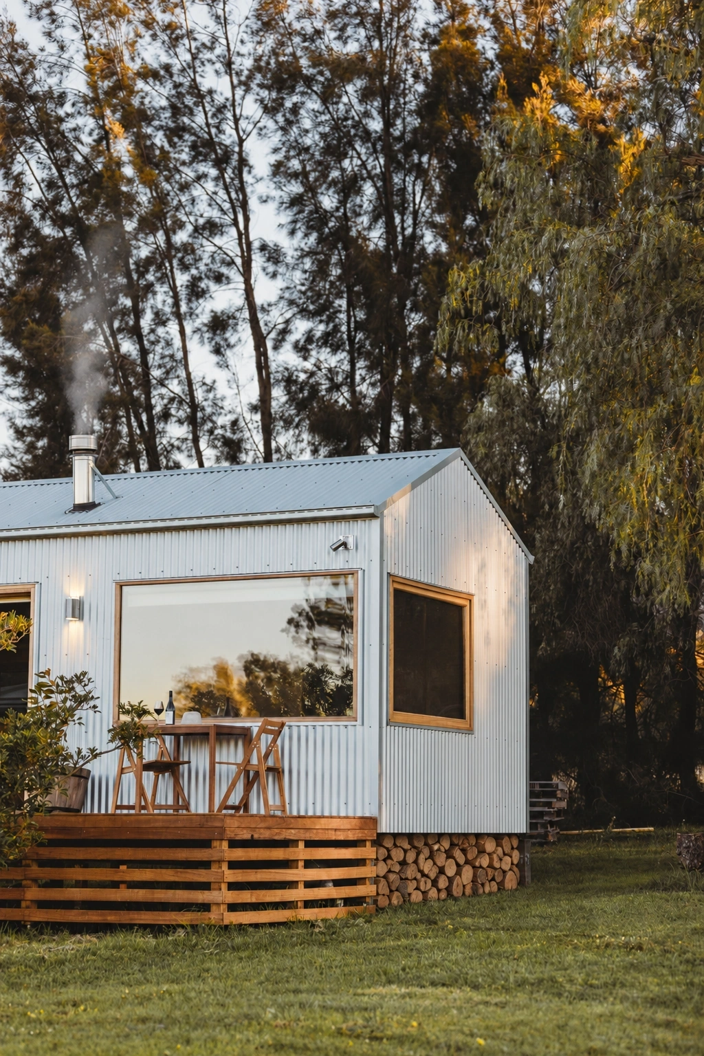Zinc Studio Oakvale cabin with timber-framed windows and a deck among the trees